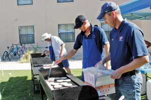 Tennis head coach Mark Roberts and Track and Field Coach Mika Laaksonen cooking for the athletes.