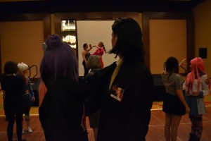 Cosplayers watch instructors as they learn to waltz for a masquerade ball.