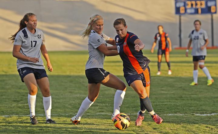 Senior midfielder Tori Martyn dribbles and attempt to elude two Utah State defenders on Aug. 30 at University Field