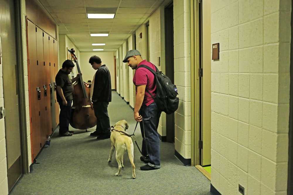 Brown and Halo walk together through the Fox Fine Arts hallways.