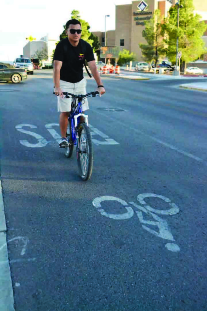 Freshman pre-engineering major Robert Portillo is one of many students that have opted to ride their bicycles in order to efficiently get around campus construction.