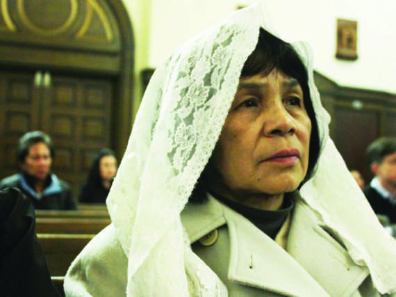 Juni Mendoza, 67 of Chevy Chase, Md., listens to sermon Wednesday at St. Thomas Apostle Church.