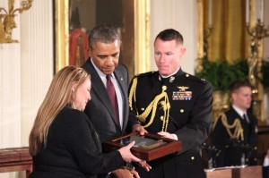 Shyrell Herrera, daughter of Sgt. Ardie R. Copas, holds President Barack Obama's hand as the military announcer reads the commendation that accompanies the Medal of Honor awarded posthumously to her father. She accepted the medal on her father's behalf. 