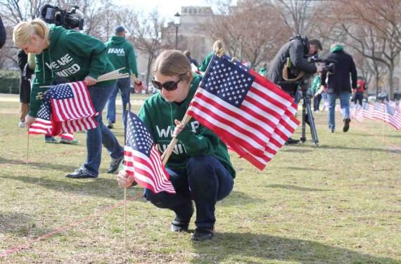 Ann Weeby, an Iraq veteran with the Michigan Army National Guard and senior business developer for Goodwill in San Francisco, plants a U.S. flags across the National Mall to represent veterans who committed suicide over the last year.