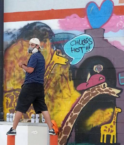Senior psychology major Joseph Peterson spray paints a wall in Downtown El Paso.