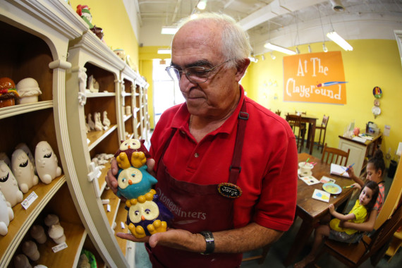 Manager Jorge Camañez holds a piggy bank, a pottery piece that was finished by a customer. 