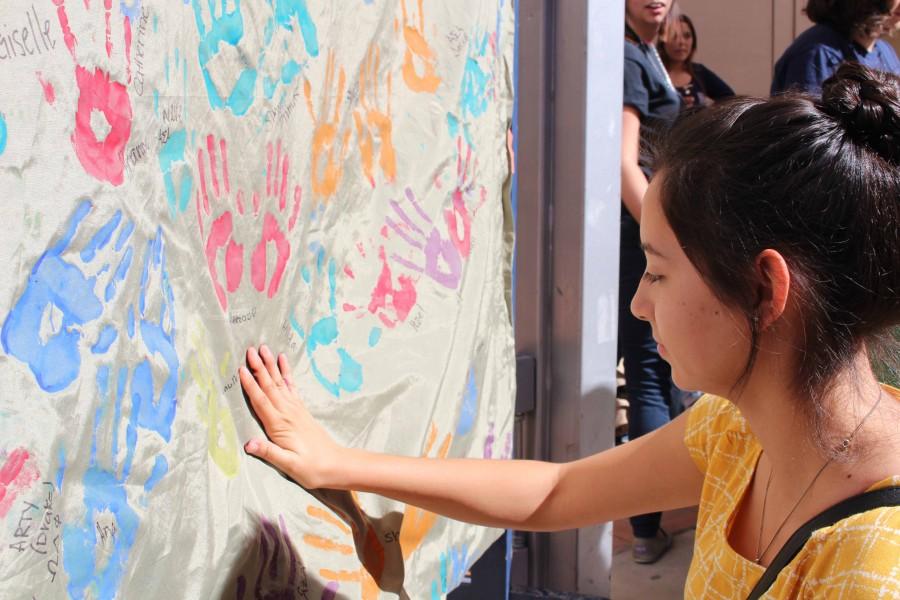 Evangelina Espinoza places her handprint on the banner. 