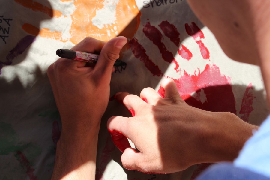 A student shows his support by signing the banner.