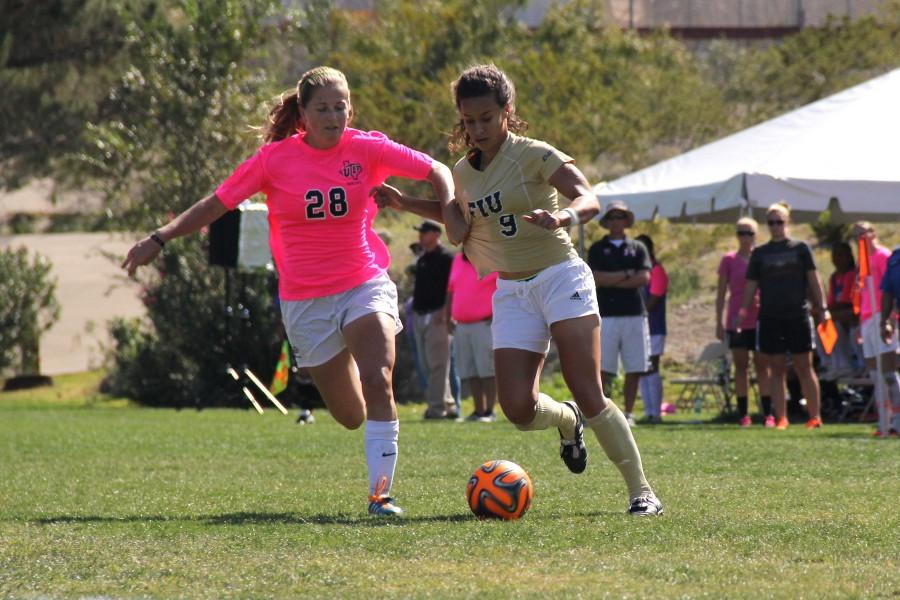 Sophomore midfielder Hannah Nicholson wins the ball against the Florida International defender this past Sunday.