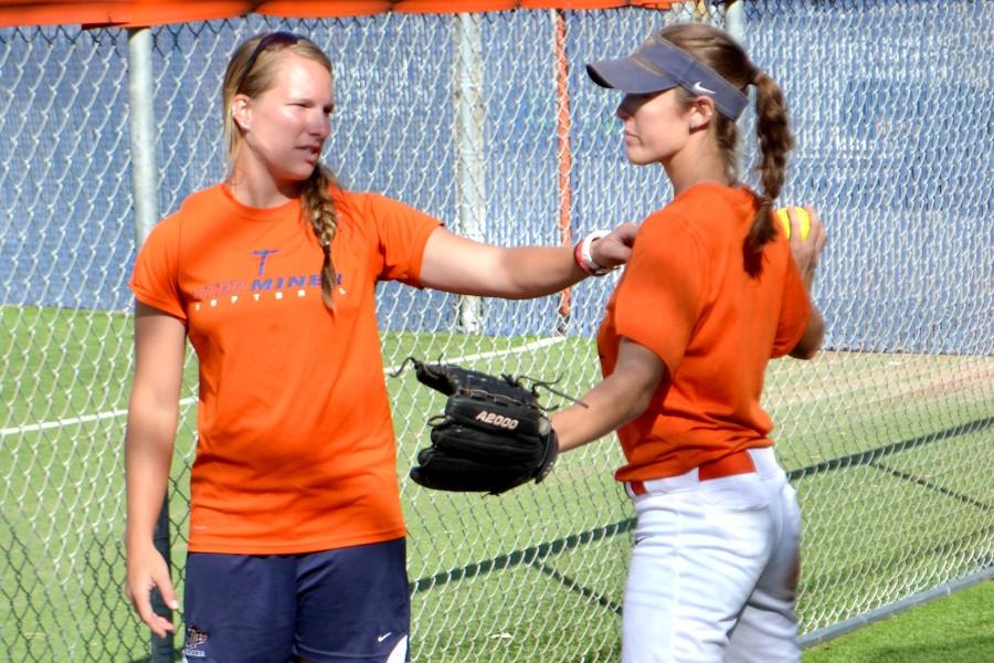 Pitching coach Sarah Plourde (left) works with junior pitcher Danielle Pearson (right) in the pitching cage.