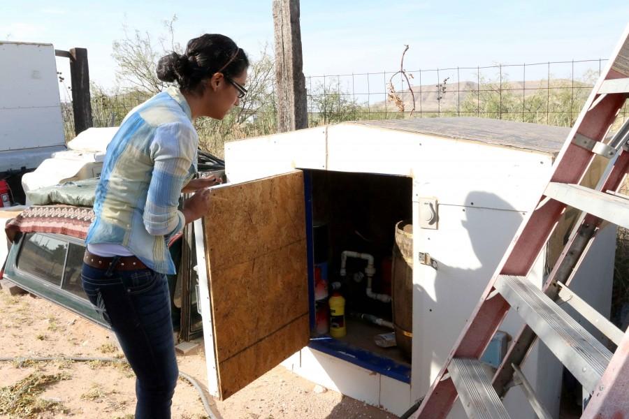 Junior multimedia journalism major Damaris Reyes demonstrates the way her family collects water for daily use.  