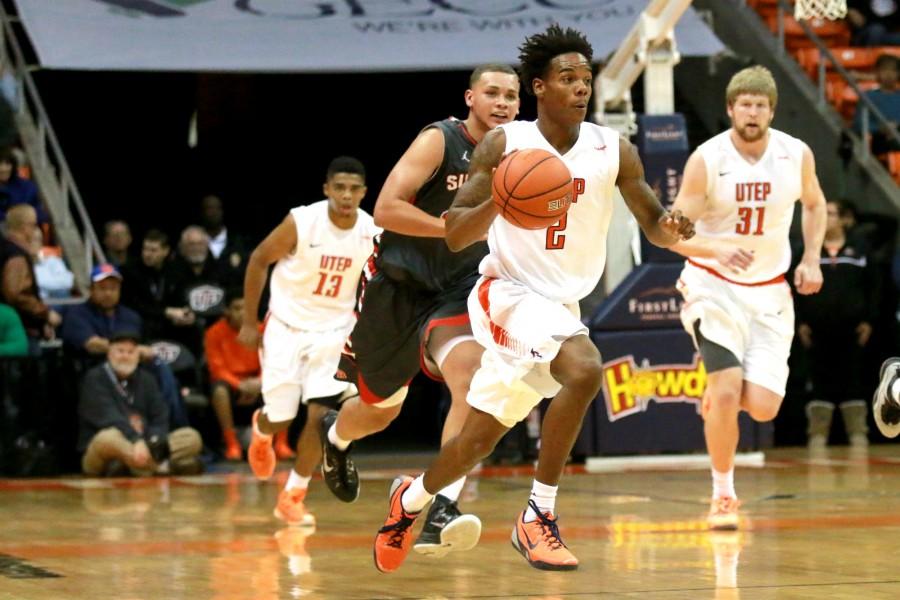 Sophomore guard Omega Harris dribbles ball towards the basket. 