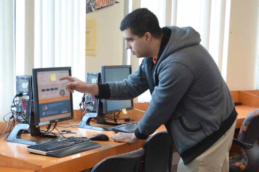 A student works at the Enrollment Services Center, which is located at the Mike Loya Academic Services Building.