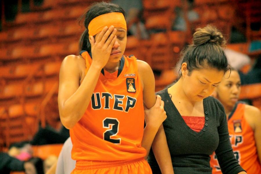 UTEP Guard Cameasha Turner is escorted off the court by the team doctor. 