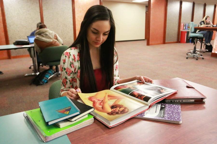Senior multimedia journalism major Ashley Bazan reads through a fashion textbook.