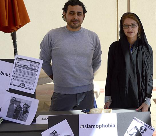Reem Issa, right, poses behind her table, which UTEP helped to set up to promote awareness toward Muslims on campus. 