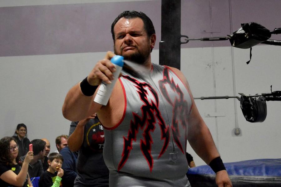 Local professional wrestler Hector Rincon uses canned air to get rid of the crowd’s bad smell.