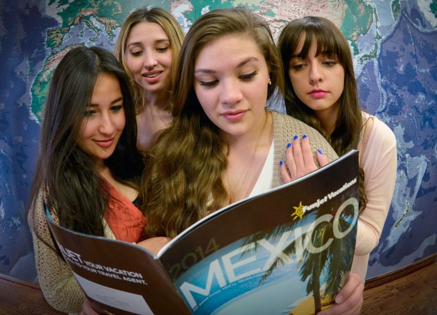 Un grupo de jovenes ven un pamfleto sobre Mexico.