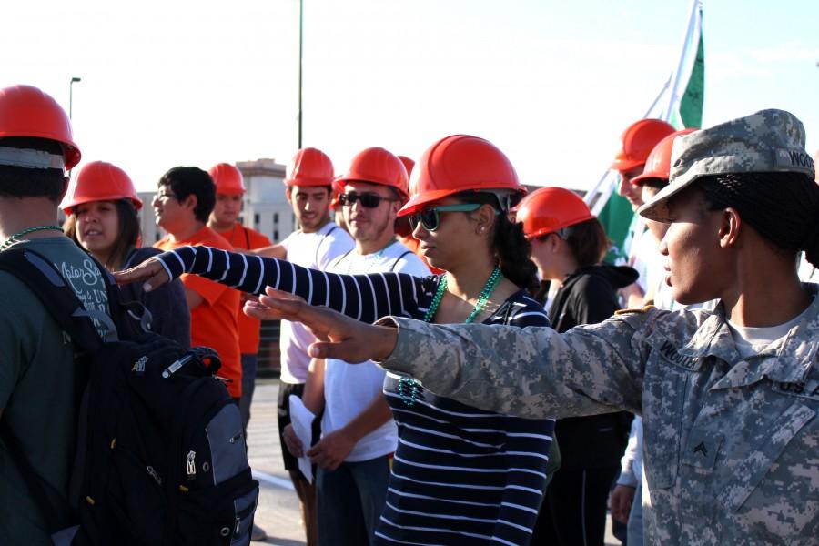 A soldier who volunteered on TCM Day shows a student the right distance from the next person. 