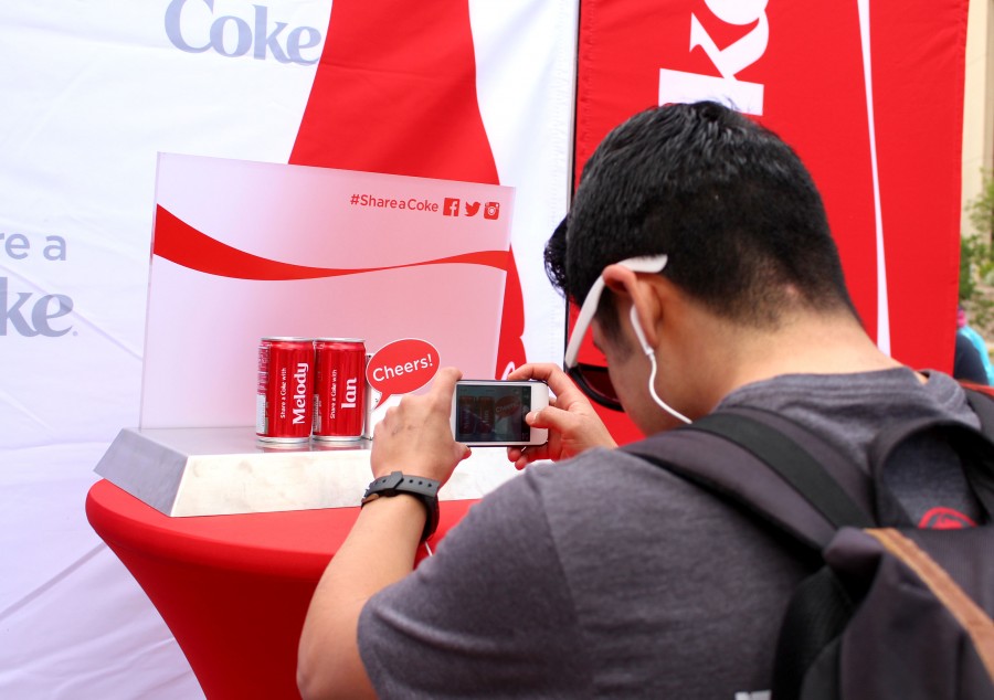 Senior history major Ian Roa takes a picture of his personalized coke to share with friends.