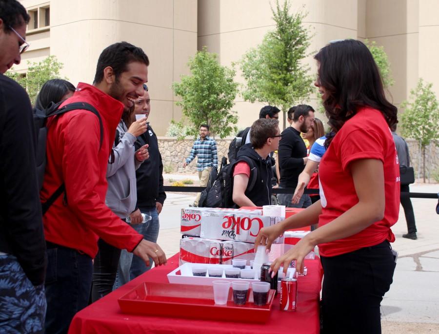 A UTEP student receives a free coke, while he waits in line.