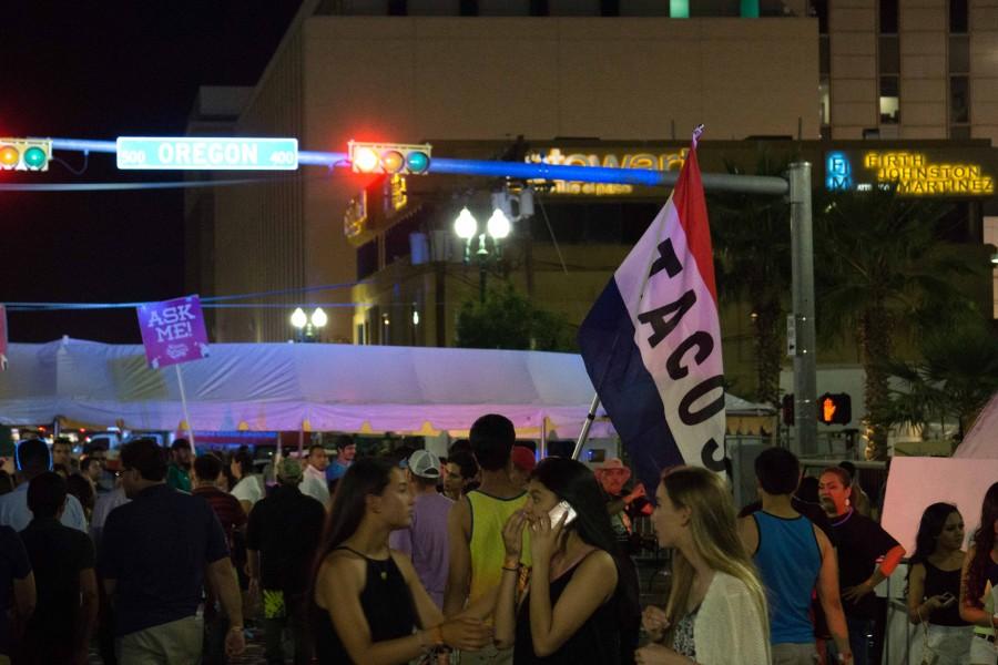 A Give Me Tacos Or Give Me Death banner hovers over festival attendees. 