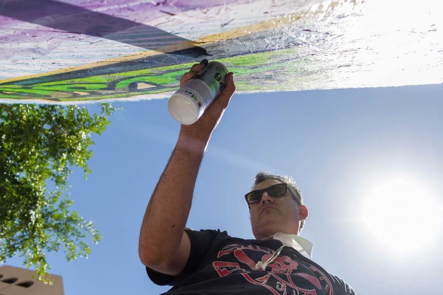 Artist Grave Herrera paints the Neon Desert board. 