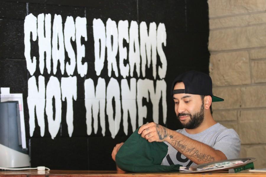 The+Dream+Chasers+Club+owner+and+founder%2C+JAM%21+folds+shirt+at+the+stores+location.