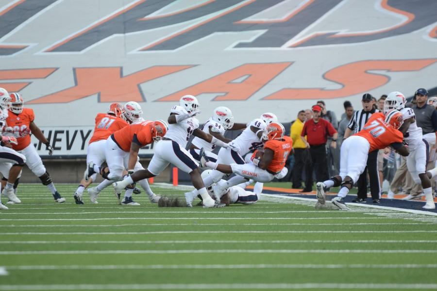 A UTEP Miner is tackled by FAU players. 