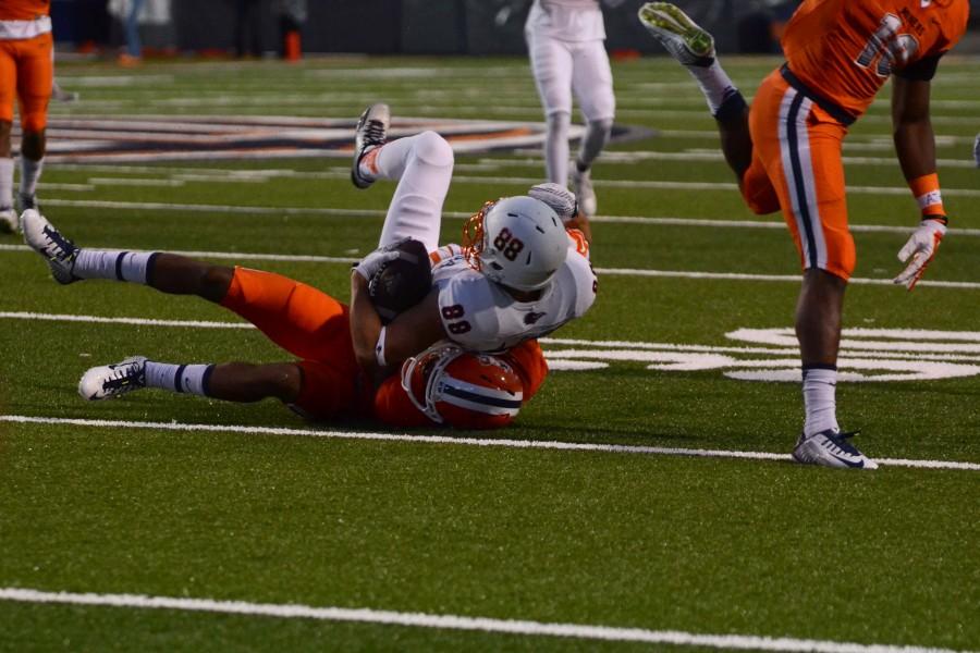 A UTSA player is taking down by a UTEP player. 