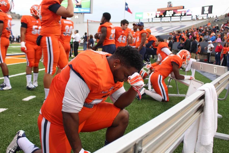 A UTEP player takes a moment to pray before the game begins. 