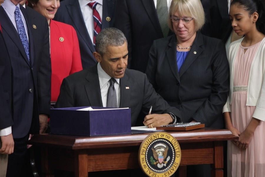 President Obama signs the Every Student Succeeds bill into law Thursday. Sen Patty Murray, D-Wash., and Sofia Rios, a eight-grade student at Kenmore Middle School in Arlington, Va., watch.