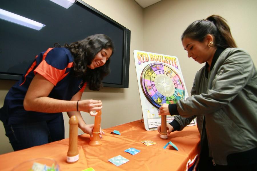 Two members of the Healthy Miners Sex Positive Peer Education Program demonstrate safe sex.