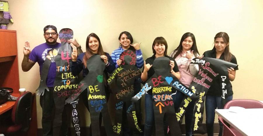 Participants of the Silhouette Project hold up their decorated silhouettes as part of the month-long project that will begin April 11 at the Mercado Mayapan with the “Fire & Ice Border Tour.”