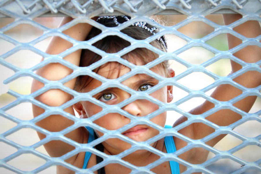 A young girl peers across the border fence into Sunland Park, New Mexico, from Ciudad Juárez, Mexico.