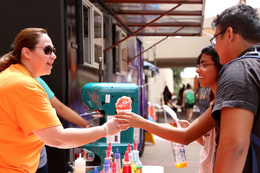 Alumni+education+major+Diana+Guerra+hands+out+snow+cones+as+part+of+the+Off+the+Grill+Food+truck.+