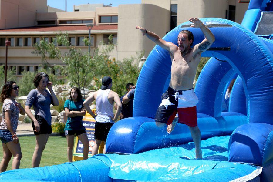 Sophomore kinesiology major Lukas Znosko makes a jump from the water slide into the little pool on the third day of school at the Centennial PLaza. 