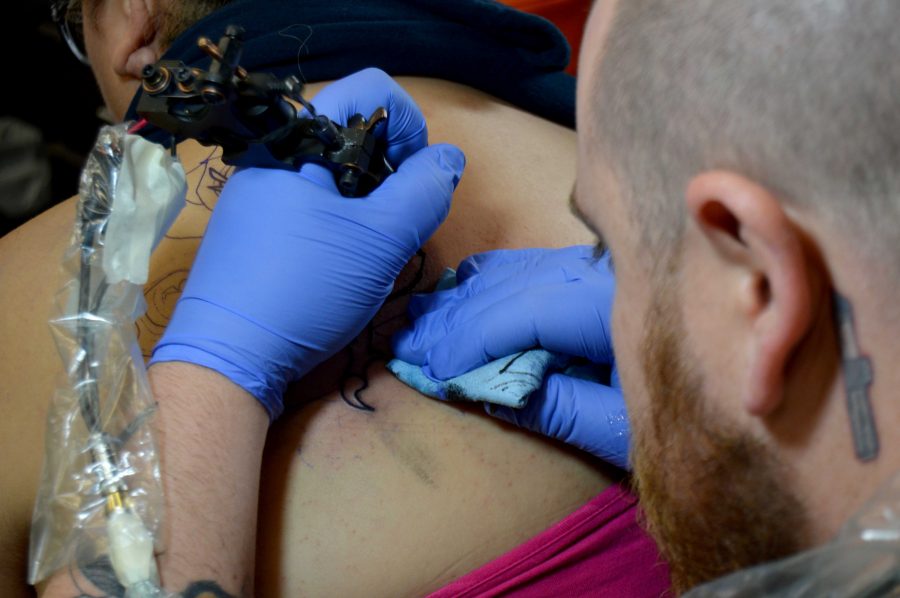 Tattoo artist Brian Stephens works on a new tattoo at Dapper Ink.