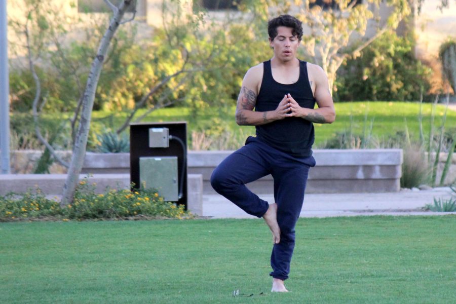 A student practices yoga in Centennial Plaza. 