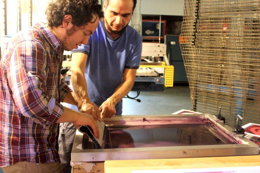 A Proper Print Shop employee helps a visitor make a print at Mighty Mujer Triathalon event. 