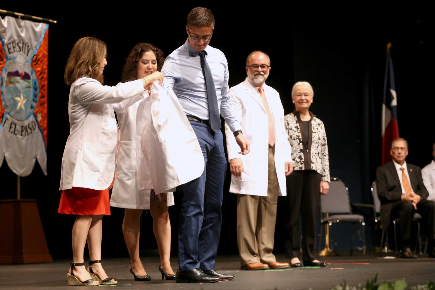Director of experiential education clinical professor Jacquelyn P. Navarrete and chair of pharmacy practice and clinical sciences clinical professor Amanda M. Loya help students put on coats during the presentation of white coats.