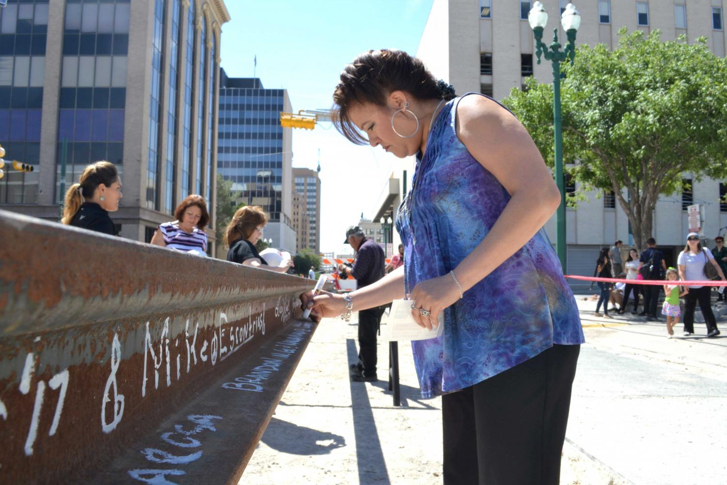 Woman signing her name in the rail at the “ Make your Mark:  Sign the Last Piece of Rail” event at Downtown El Paso on August 10.