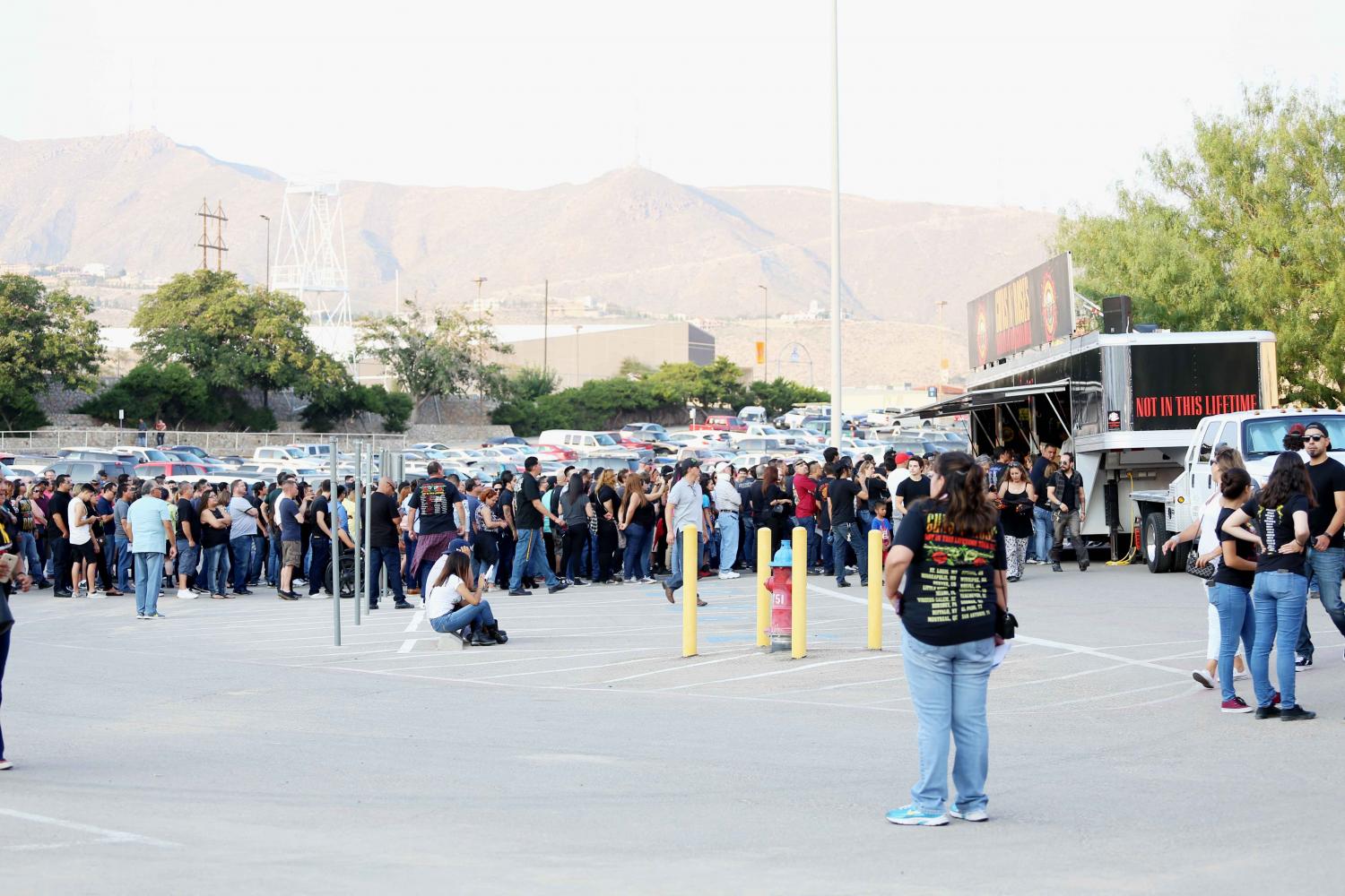 People line up to buy Guns N' Roses t-shirts.