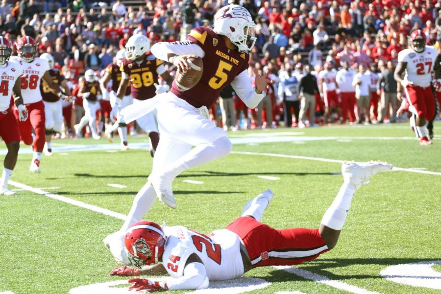 ASU quarterback Manny Wilkins avoids NC State defender Shawn Boone.