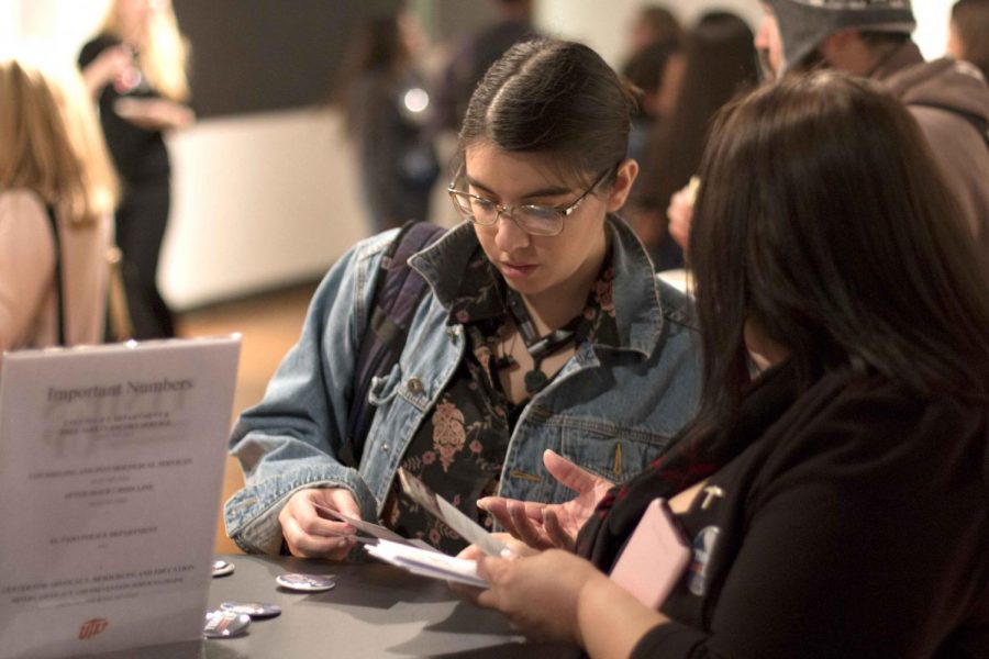 Two attendees of the Student Engagement & Leadership Centers Times Up event write messages to stand with sexual assault survivors on Friday, Jan. 26, at the Union East gallery. 