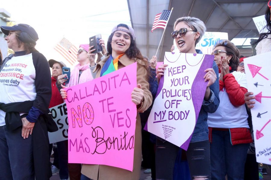 Two+participants+in+the+Womens+March+El+Paso+2018+hold+signs+at+Centennial+Plaza.