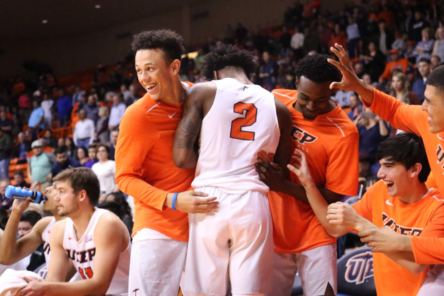 Senior guard Omega Harris hugs his teammates, after receiving a standing ovation from the home crowd.