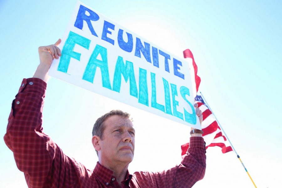 People held up signs behind the media  during the press conference at the Tornillo- Guadalupe Port of Entry. 