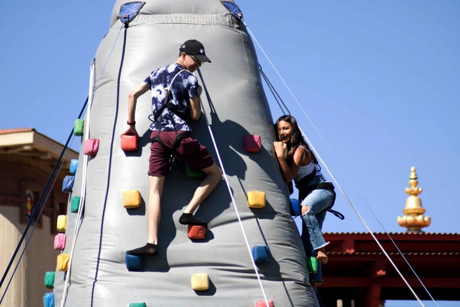 Junior mechanical engineering major Luis Nuñez and senior forensic science major Gema Espinoza climb up the rock wall.