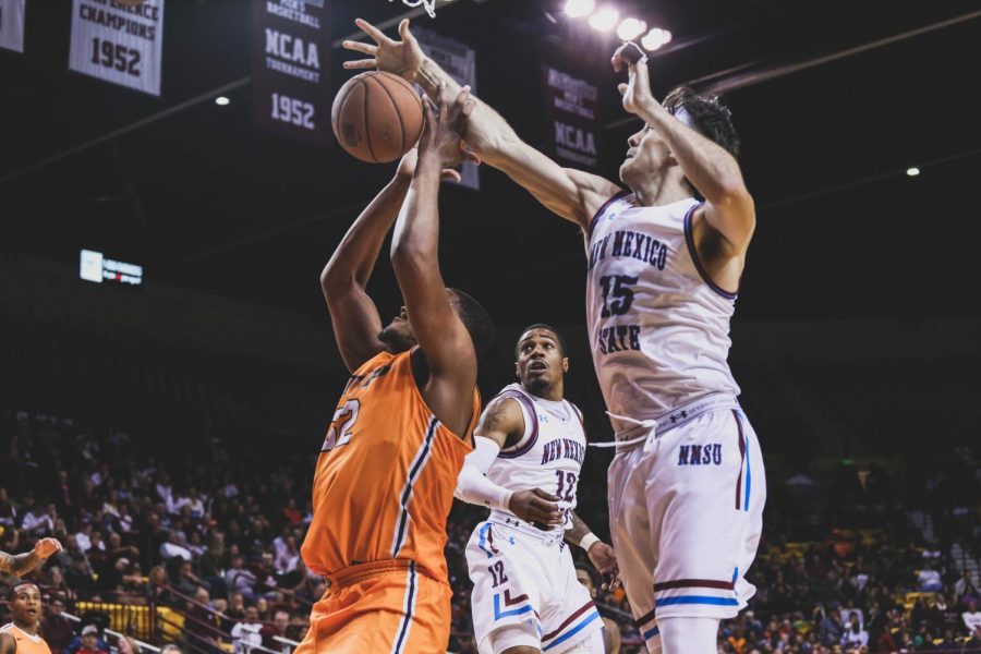 Freshman forward Efe Odigie is blocked by NMSU junior forward Ivan Aurrecoechea. 